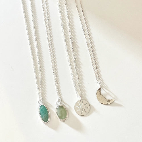 קולקציית שרשראות כסף בעבודת יד מסטודיו שירו, הכוללת תליוני חצי ירח, אבני חן ועיצובים גאומטריים נקיים.