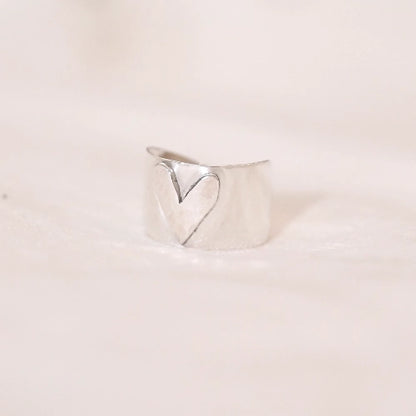 טבעת כסף 925 דגם Amore בעיצוב רחב עם לב חרוט במרכז, עבודת יד רומנטית של Shiroo המעניקה מראה ייחודי ובעל נוכחות.