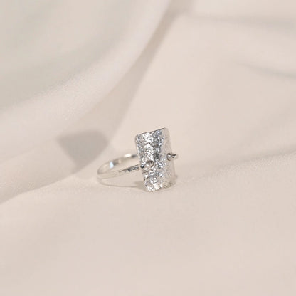 טבעת כסף סטרלינג מרוקעת במבט מהצד, מדגישה את הטקסטורה הייחודית והניגוד בין הקווים הישרים לקימורים העדינים.