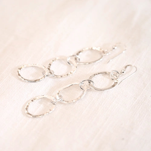 עגילי כסף תלויים Unita בעיצוב של שלושה חישוקים עדינים המשתלבים יחד, עבודת יד של Shiroo למראה אלגנטי ובעל נוכחות.