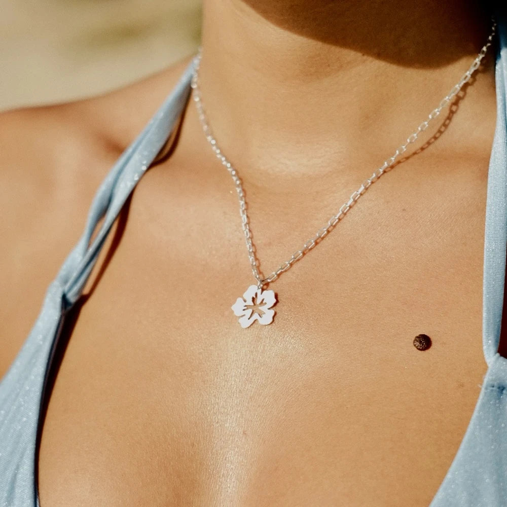 שרשרת כסף 925 עם תליון פרח היביסקוס במבט מקרוב על הצוואר, תכשיט בעיצוב אורגני וקליל לקיץ.