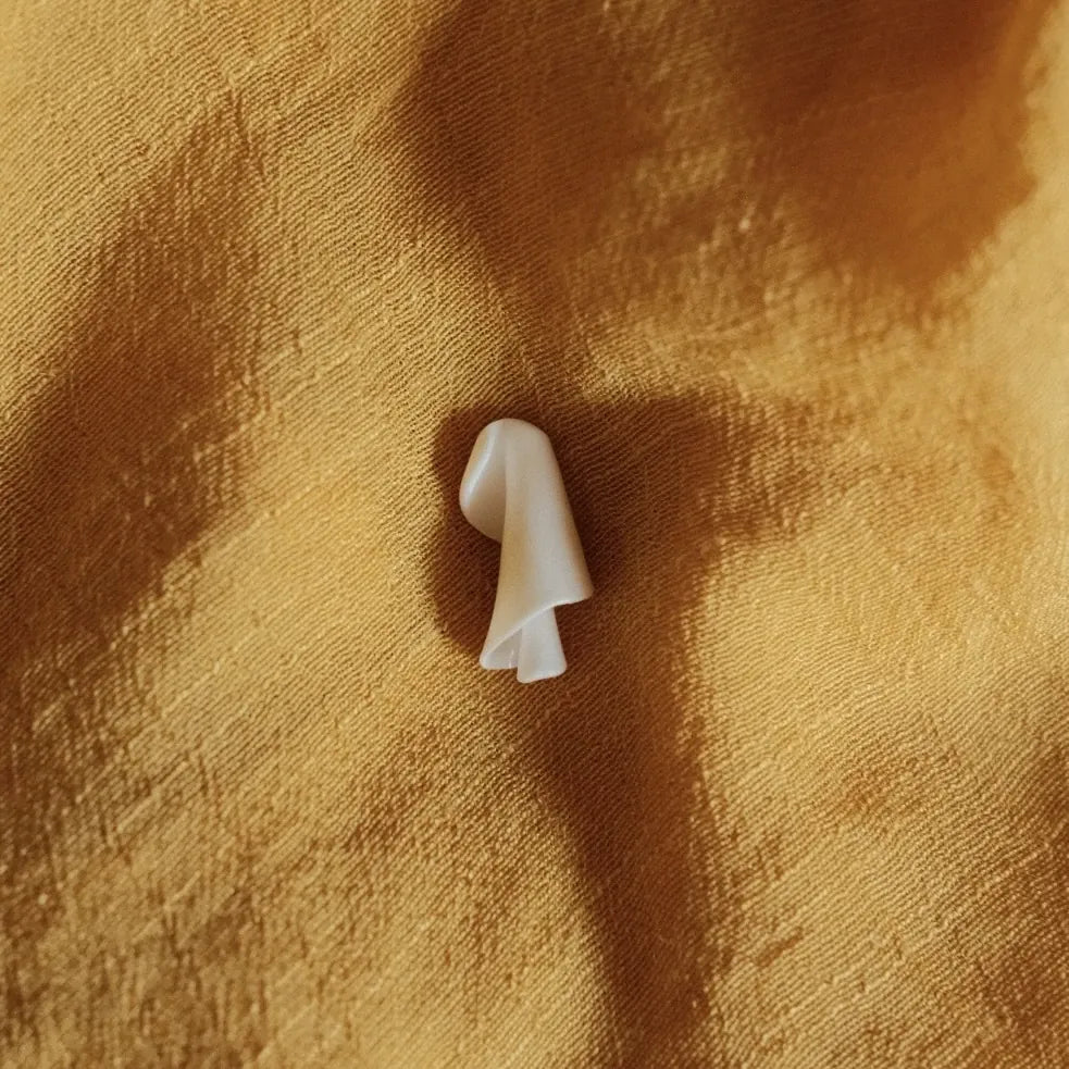 מבט מקרוב על הטקסטורה של תליון ספירלה מכסף, עבודת צורפות מוקפדת המדגישה את איכות החומר והעיצוב.