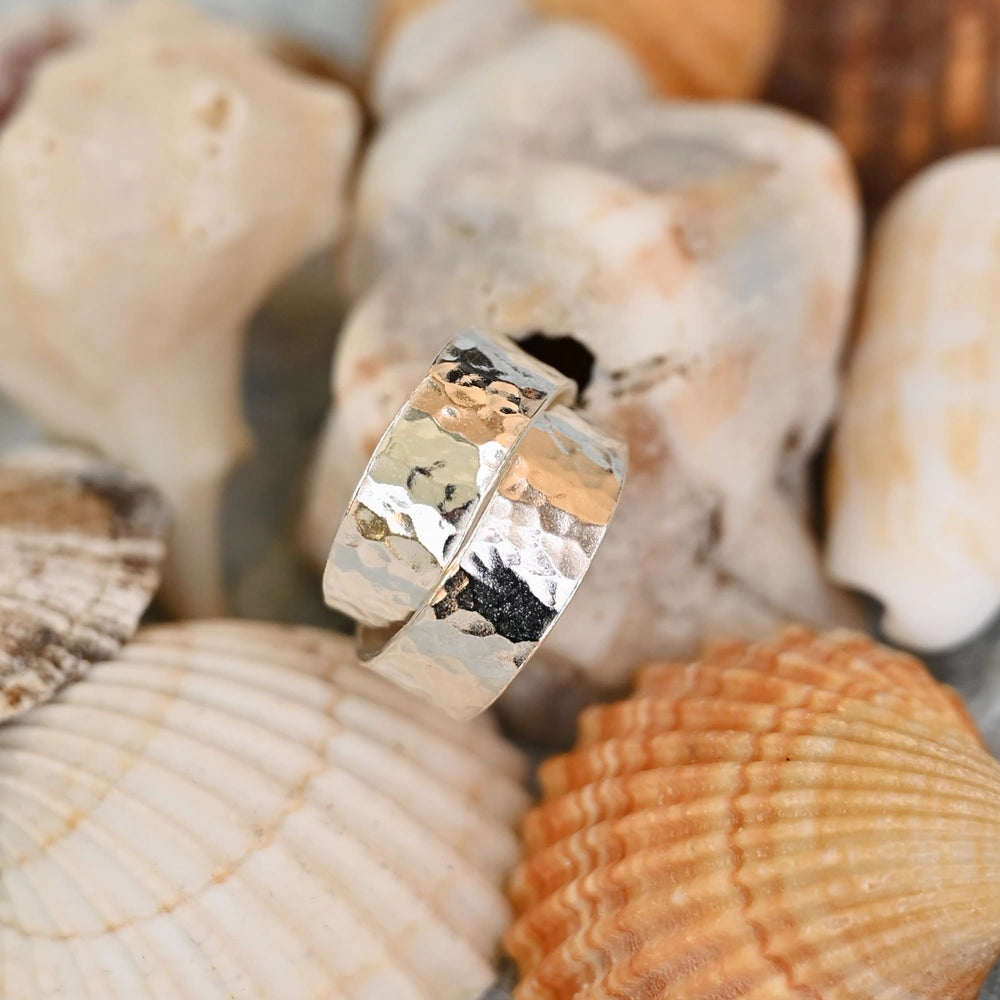 תכשיטי כסף בעבודת יד מקולקציית הקיץ של שירו, עגילי ריקוע עגול על רקע צדפי ים.