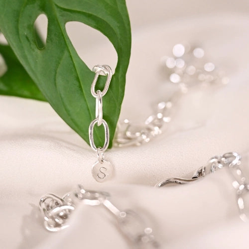 מבט מקרוב על חוליות מרובעות קטנות בצמיד כסף, עבודת צורפות מוקפדת המדגישה את איכות הגימור.