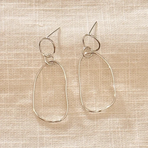 זוג עגילי כסף סטרלינג שירו במבט מקרוב, המציגים עיטורי צורפות נקיים וסגנון אלגנטי-קלאסי עם טוויסט ייחודי.