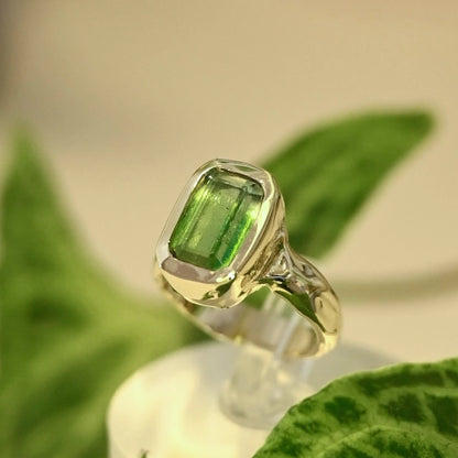 טבעת זהב 14 קראט בעבודת יד בעיצוב אורגני, משובצת אבן טורמלין ירוקה מלבנית על רקע עלים