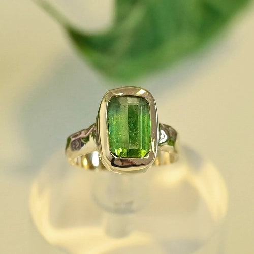 טבעת זהב 14 קראט עם אבן טורמלין ירוקה על רקע טבעי, עיצוב בהשראת הטבע מבית Shiroo