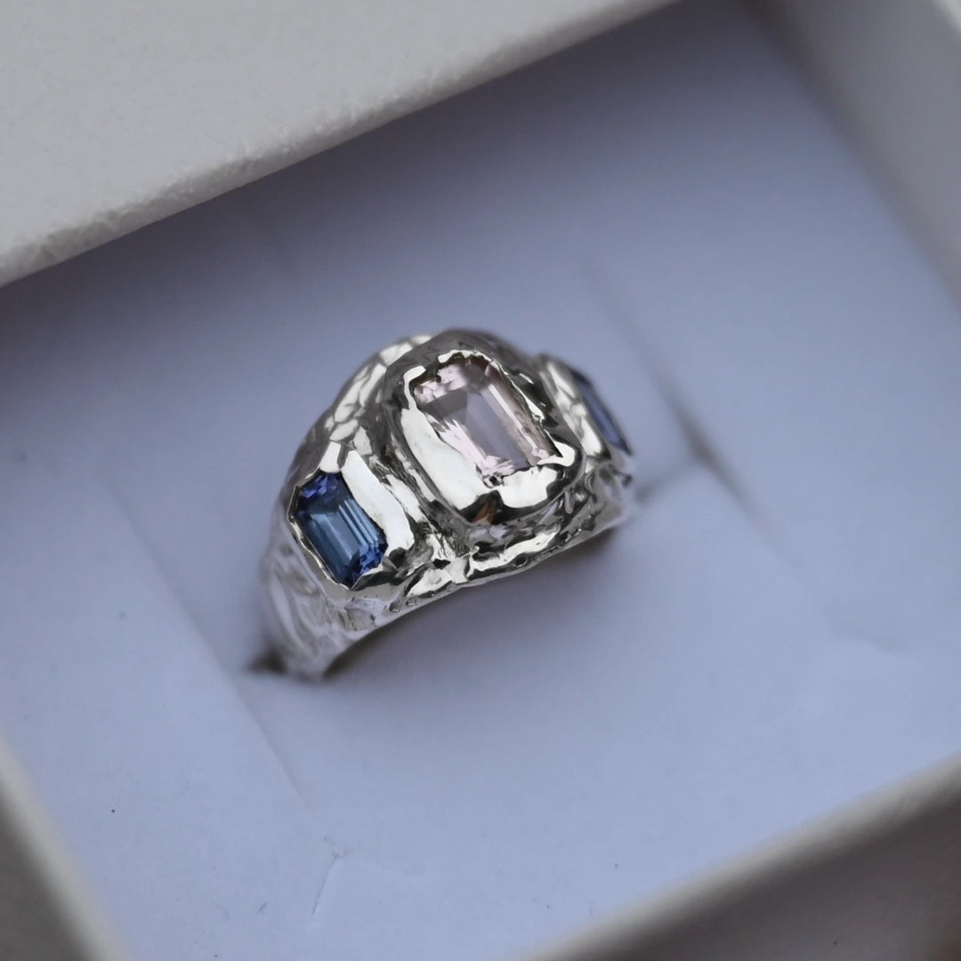 טבעת כסף 925 בעבודת יד בעיצוב אורגני, משובצת אבן מורגנייט ורודה בחיתוך אמרלד ושתי אבני טנזנייט כחולות בצדדים.