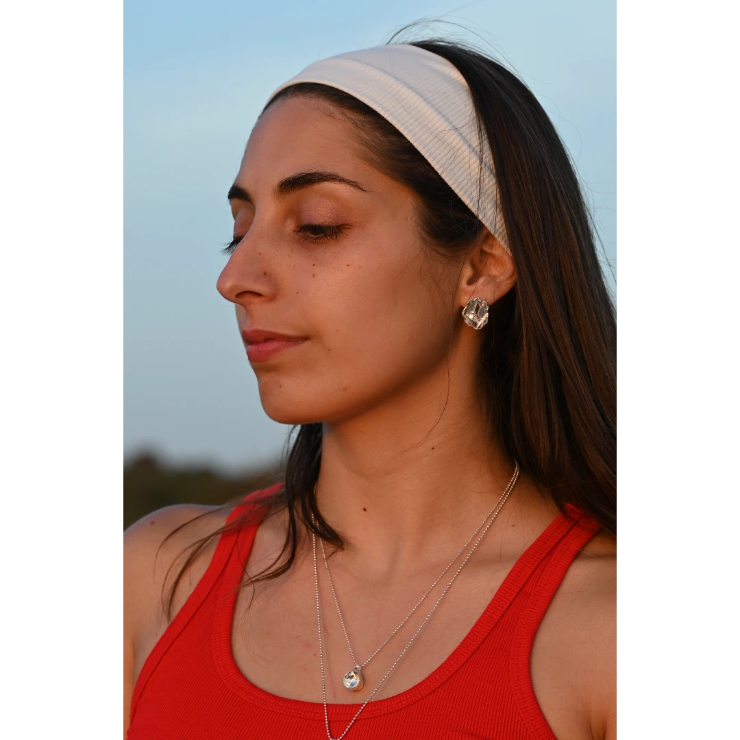 עגילי כסף אמאלפי של SHIROO, פרופיל צד של הדוגמנית על רקע שמיים כחולים. בשילוב שרשרת כסף כדור עדינה. עגילי כסף 925 עבודת יד תוצרת ישראל.