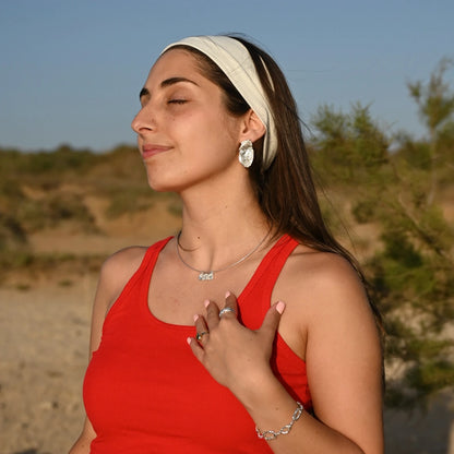 דוגמנית ישראלית עם שרשרת כסף גלים לרוחב SHIROO על צ'וקר קשיח ועגילי כסף גדולים – נוף מדברי ישראלי, לוק קיצי חופשי. תכשיטי כסף לאישה עיצוב ישראלי